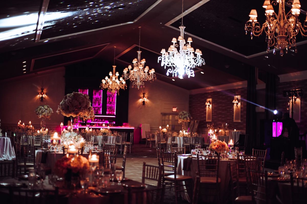 The Ballroom at night, candlelit tables beneath glowing crystal chandeliers