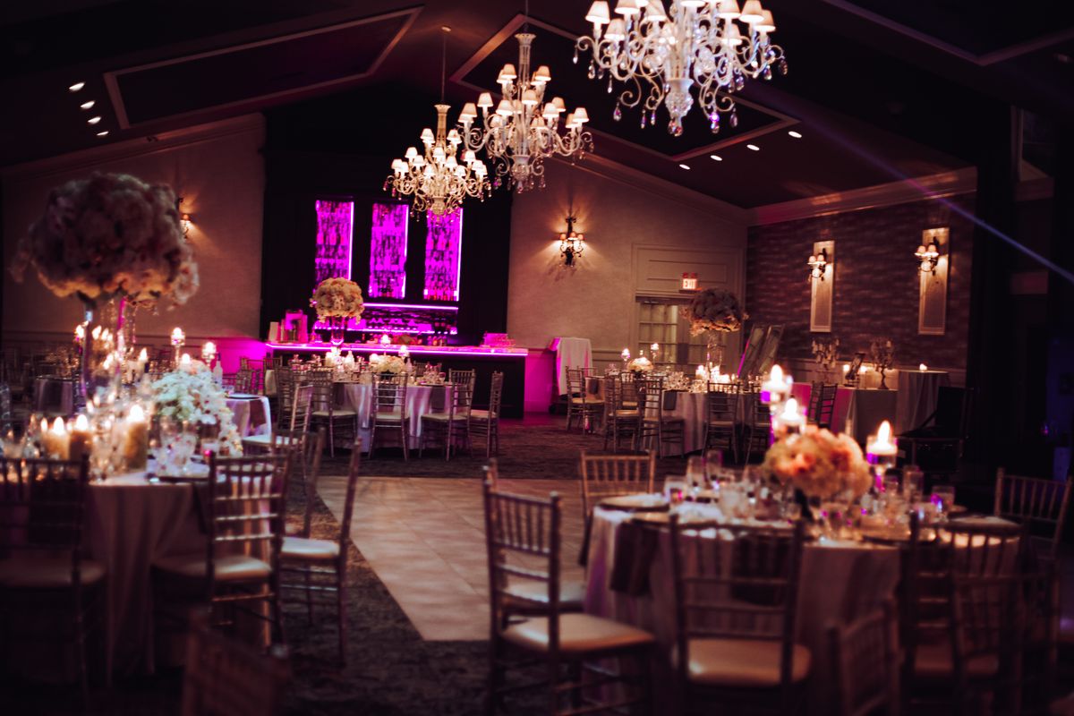 Ballroom dance floor under chandeliers and uplighting