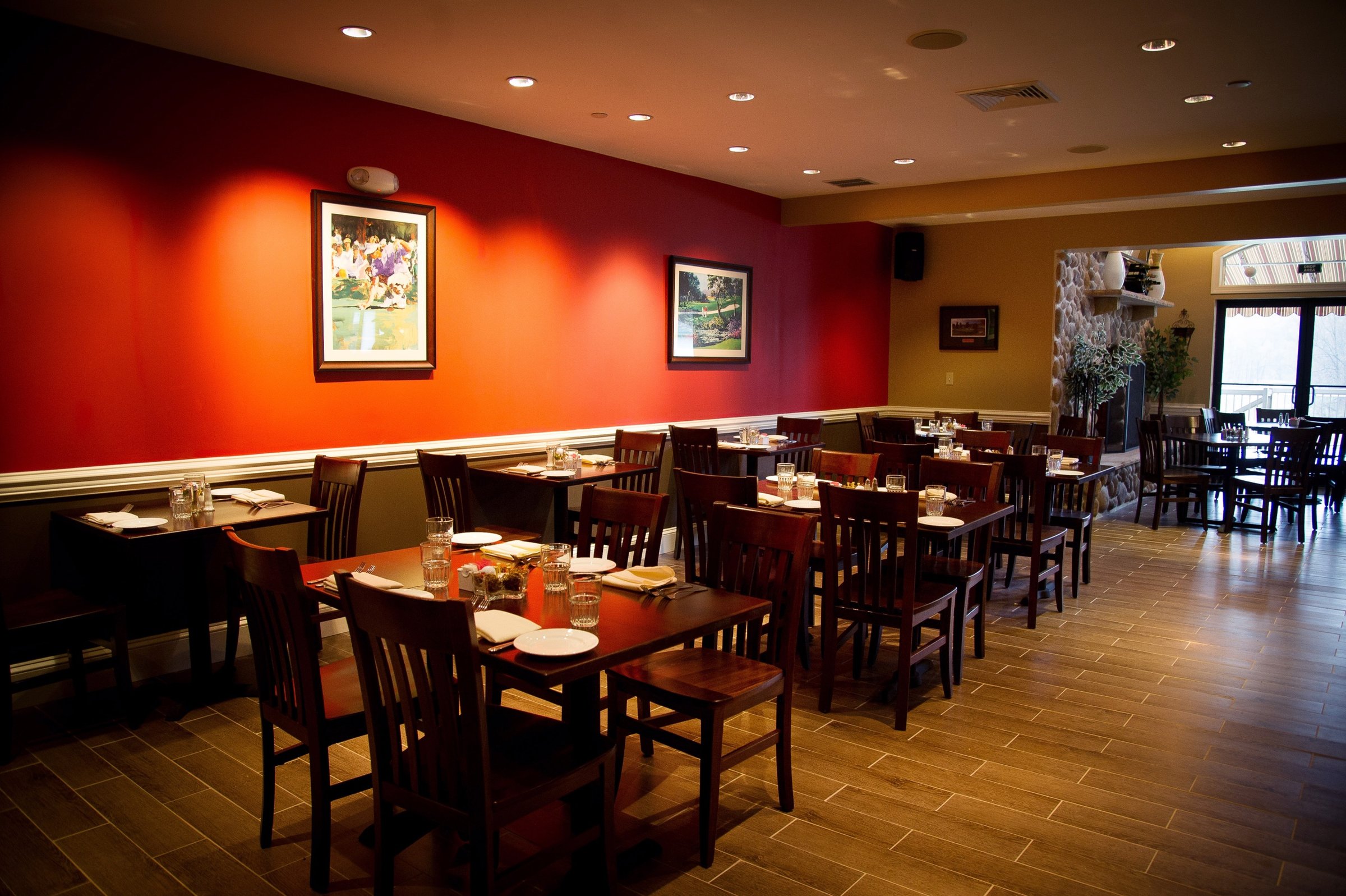 The dining room at Anthony’s at Paxon, with tables set beneath framed golf prints