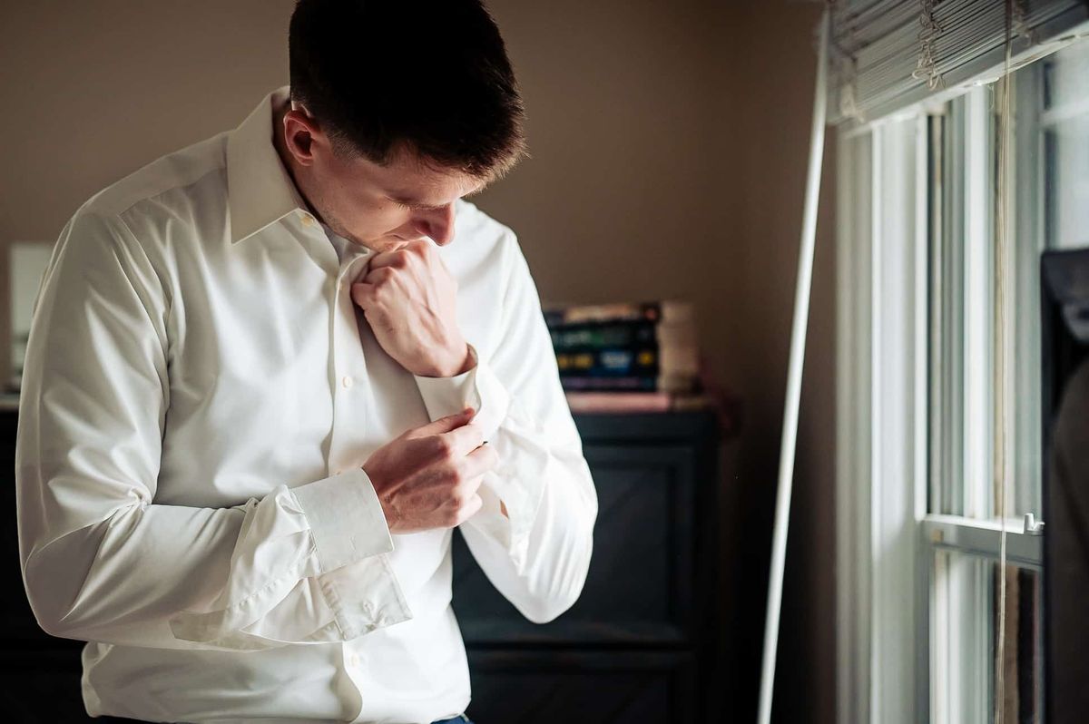 Groom fastening his cufflinks