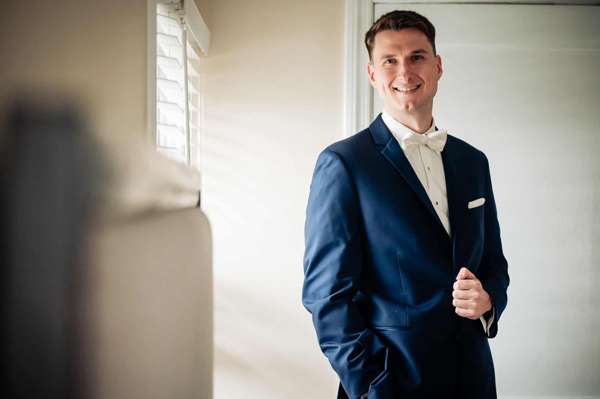 Groom smiling in his navy suit