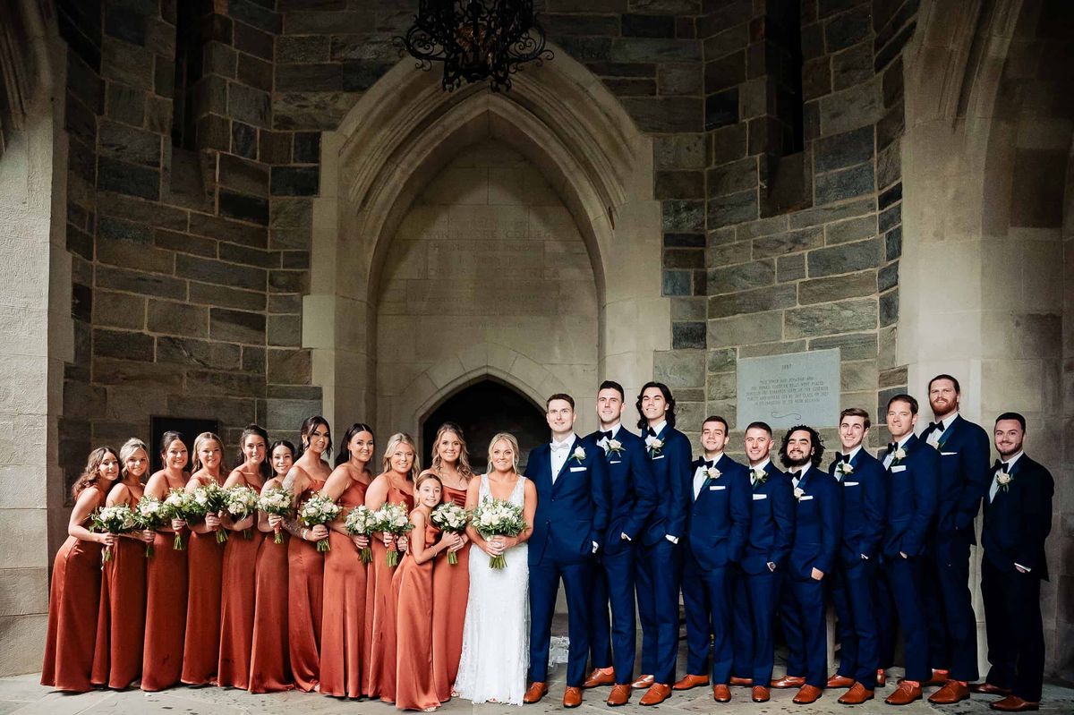 Wedding party in rust gowns and navy suits