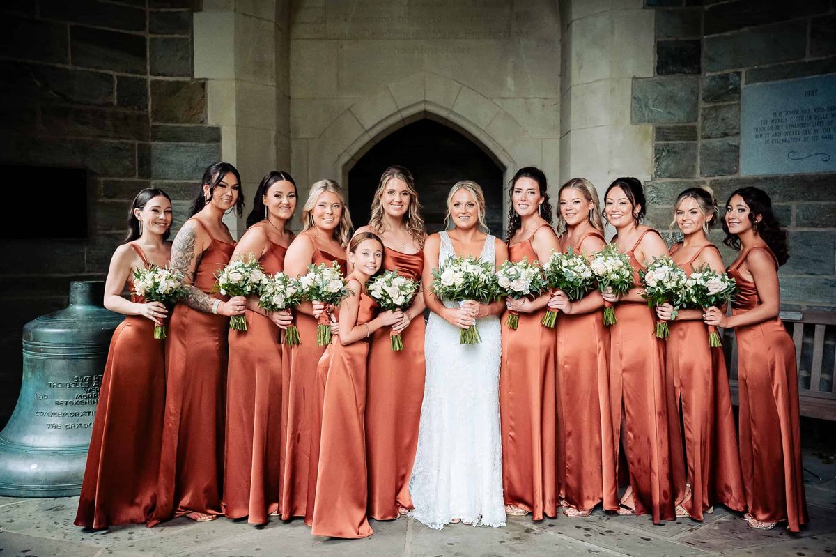 Bride with her bridesmaids in rust satin gowns