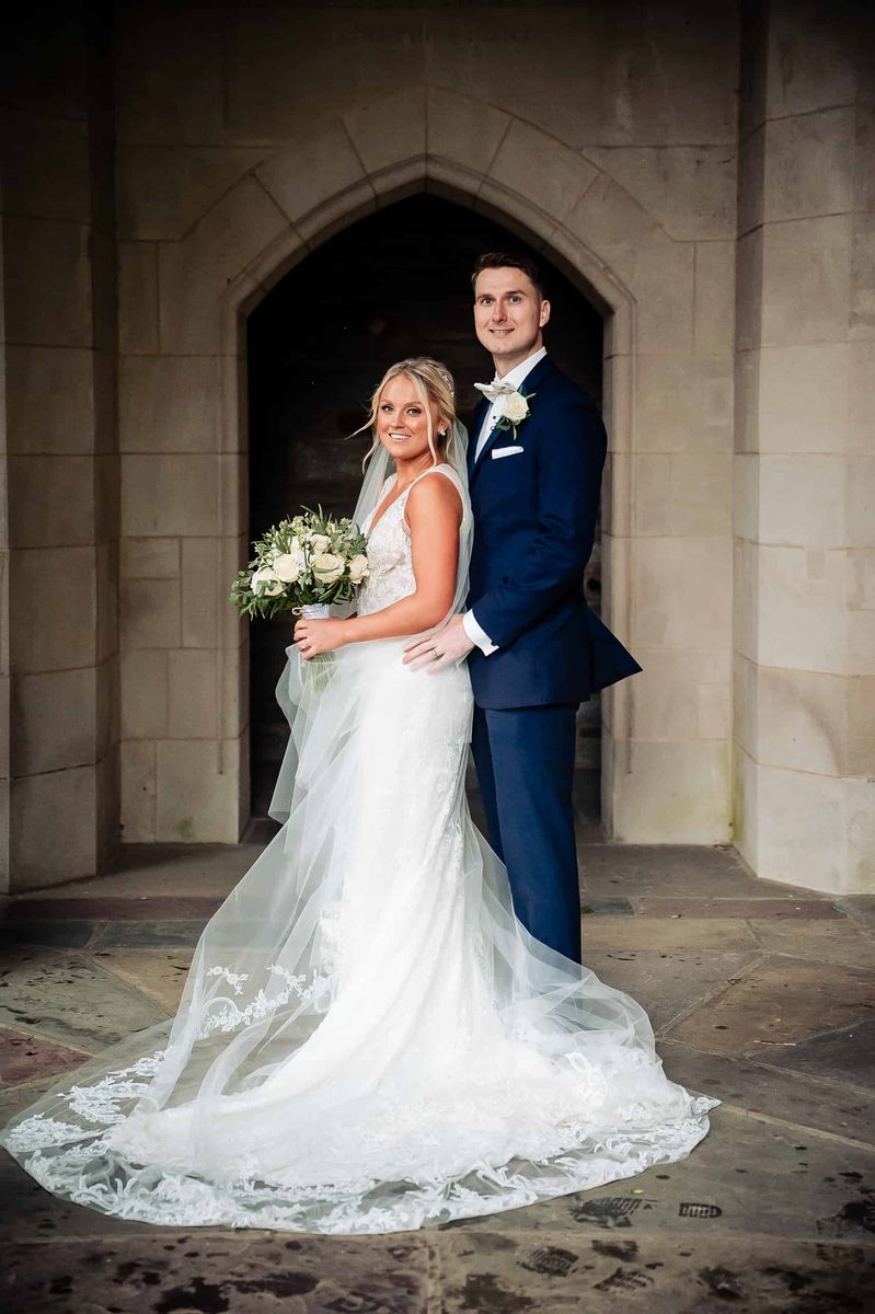 Bride and groom under a stone arch