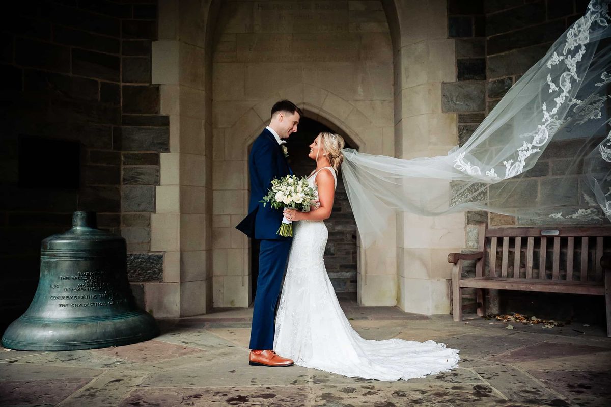 Couple beside a bronze bell, veil flowing