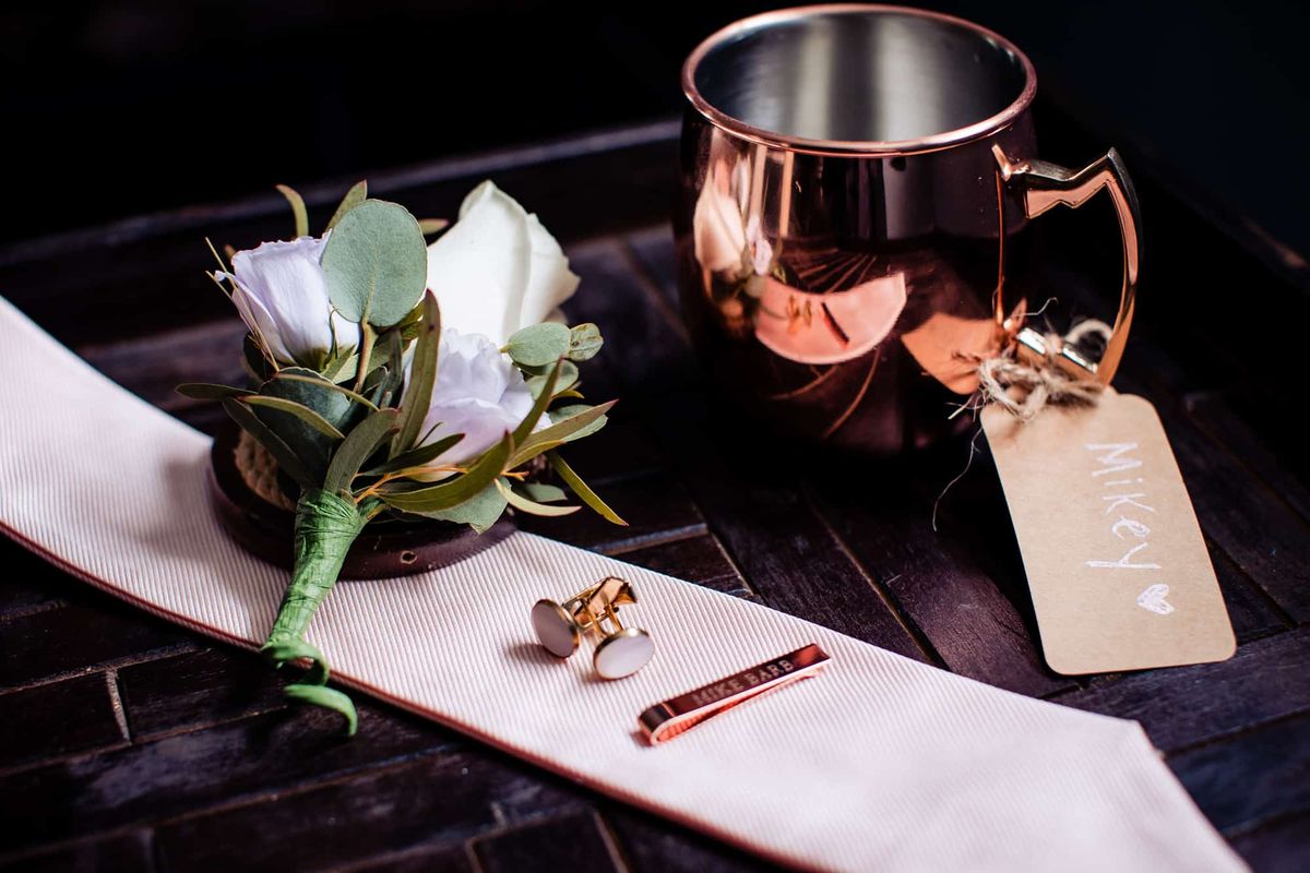 Boutonnière, cufflinks and a copper mug