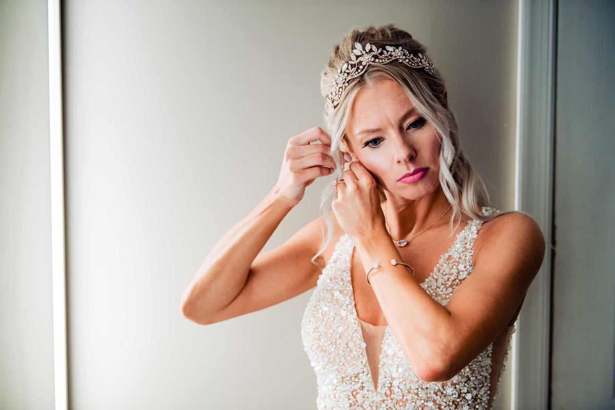 Bride putting on her earrings