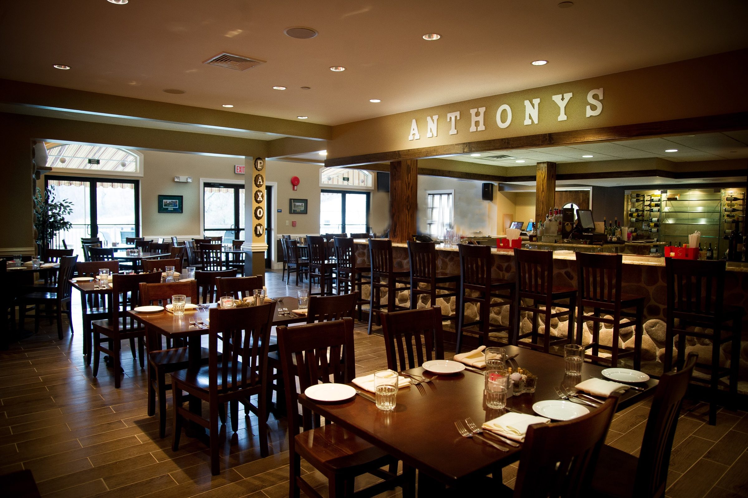 The restaurant dining room and stone bar beneath the Anthonys sign